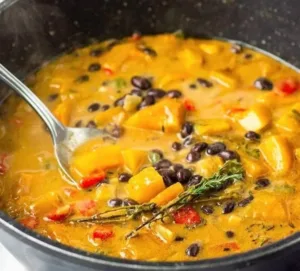 Black Bean and Butternut Squash Stew 3 A bowl of black bean and butternut squash stew garnished with herbs.