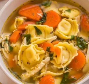Creamy Chicken Tortellini Soup 5 Bowl of creamy chicken tortellini soup garnished with herbs and spices.