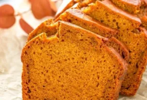 Pumpkin Bread 4 Homemade pumpkin bread loaf topped with spices and garnished with pumpkin seeds.