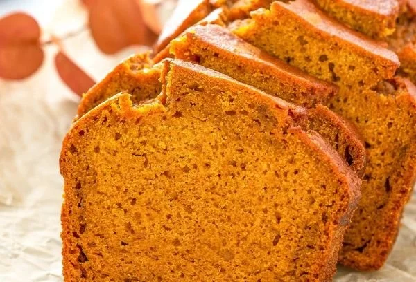 Pumpkin Bread 2 Homemade pumpkin bread loaf topped with spices and garnished with pumpkin seeds.