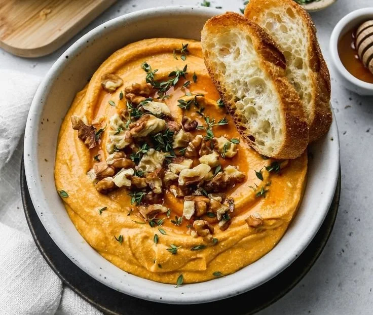 Pumpkin Crostini topped with whipped feta and garnished with herbs.