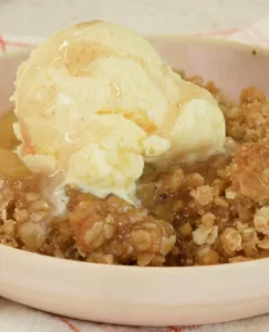 Delicious homemade apple crisp served in a bowl with a scoop of vanilla ice cream