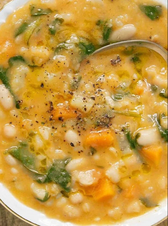 Bowl of the best white bean soup topped with fresh herbs