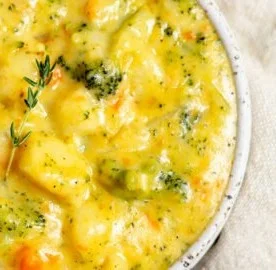 Delicious bowl of broccoli potato cheese soup garnished with fresh herbs