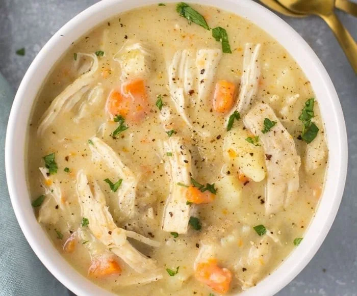 Chicken Pot Pie Soup Better Than Takeout 2 A comforting bowl of Chicken Pot Pie Soup, better than takeout, garnished with herbs.