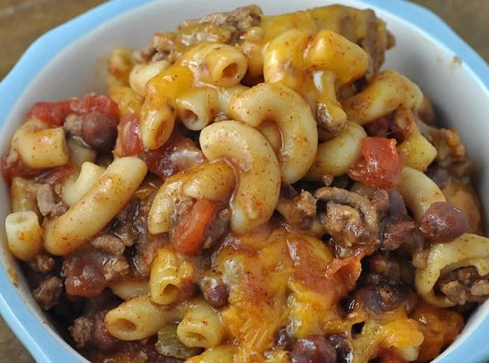 Crock Pot Cheddar Chili Mac dish served in a bowl with cheese on top.