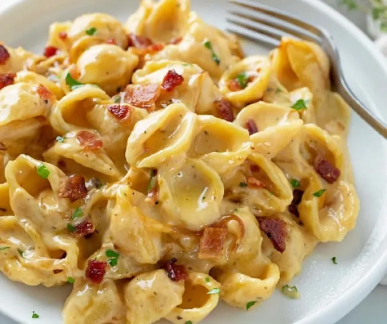 Bacon Mac and Cheese with caramelized onions served in a bowl.