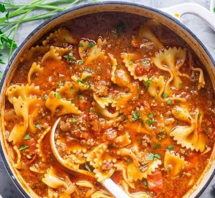 Bowl of easy one-pot lasagna soup with cheese and herbs garnished on top.