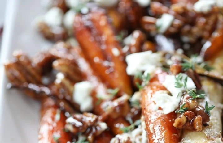 Easy roasted carrots with candied pecans and goat cheese on a serving platter