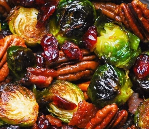 Thanksgiving Side Dish - Brussels sprouts with Bacon, Pecans, Cranberries, and Balsamic Glaze. 2 Brussels sprouts with bacon, pecans, cranberries, and balsamic glaze on a plate.