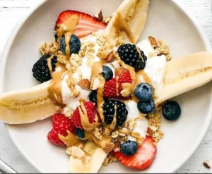 Delicious breakfast banana split with yogurt and fresh fruits