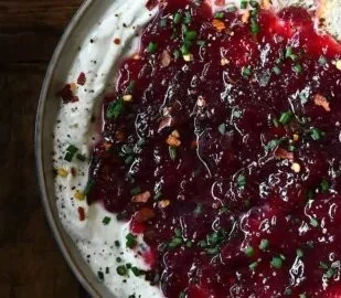 Home Loinzou 10 Delicious Cranberry Boursin Dip in a serving bowl with crackers nearby