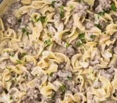 Easy Ground Beef Stroganoff in 30 Minutes 5 Easy Ground Beef Stroganoff served on a plate with noodles and herbs.