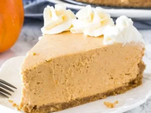 Easy Pumpkin Cheesecake 6 Slice of easy pumpkin cheesecake topped with whipped cream on a plate