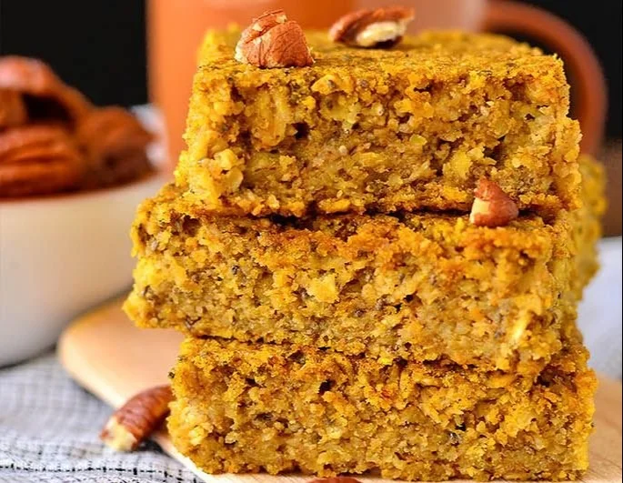 Maple Pumpkin Oatmeal Breakfast Bars - Gluten Free 2 Gluten-free maple pumpkin oatmeal breakfast bars on a wooden table